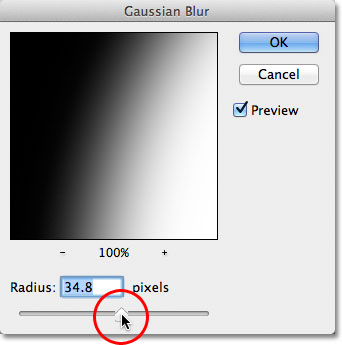 Dragging the Radius slider in the Gaussian Blur dialog box in Photoshop. Image © 2011 Photoshop Essentials.com