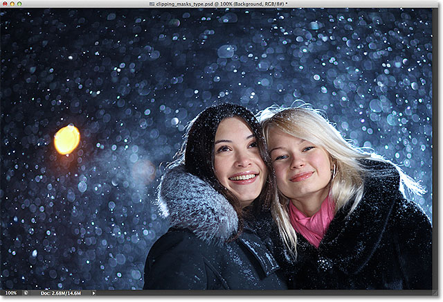 Two happy young female friends enjoying snowfall on Christmas winter night over snow background. Image licensed from Shutterstock by Photoshop Essentials.com