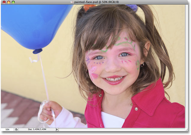 A photo of a young girl with a painted face holding a balloon. Image used by permission from iStockphoto.com