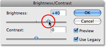 Dragging the Brightness slider to increase brightness in the image. Image © 2009 Photoshop Essentials.com