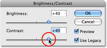Dragging the Contrast slider in the Brightness/Contrast dialog box. Image © 2009 Photoshop Essentials.com