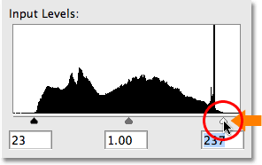 Setting a new white point by dragging the white point slider to the right edge of the histogram. Image © 2009 Photoshop Essentials.com