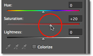 Dragging the Saturation slider in the Properties panel. Image © 2012 Photoshop Essentials.com