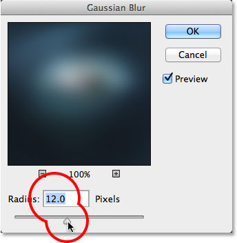 Dragging the Radius slider in the Gaussian Blur dialog box. Image © 2014 Photoshop Essentials.com