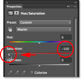 Dragging the Saturation slider to the left in the Properties panel. Image © 2014 Photoshop Essentials.com